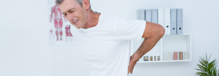 A man reaching toward his lower back
