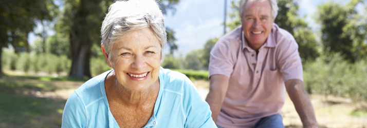 Two older adults smiling outdoors