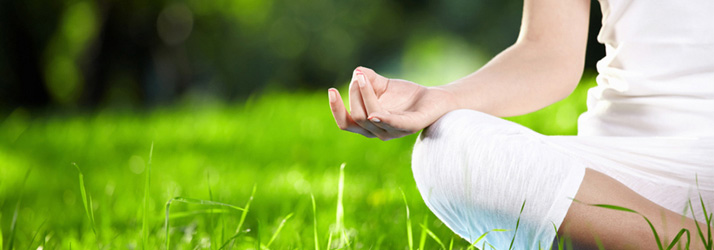 A person sitting cross-legged on grass