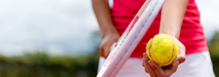 A person holding a tennis racket and ball