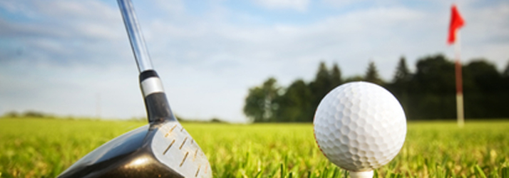 A golf club beside a ball on a tee