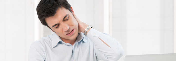 A man resting a hand on the back of his neck