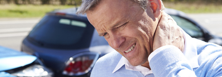 A man holding his neck beside a car