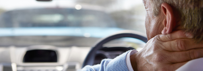 A driver with one hand on the back of their neck