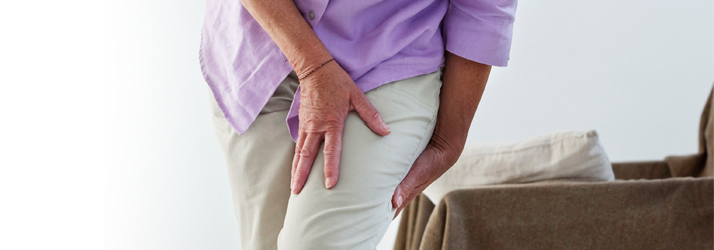 A seated person with a hand on their thigh