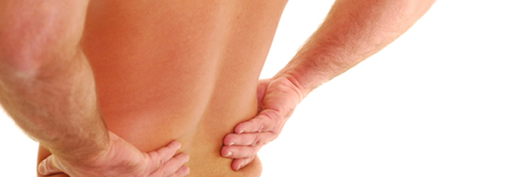 A person resting both hands on their lower back