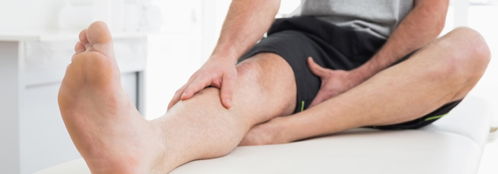 A person holding their lower leg while seated