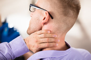 A man resting his hand on the back of his neck