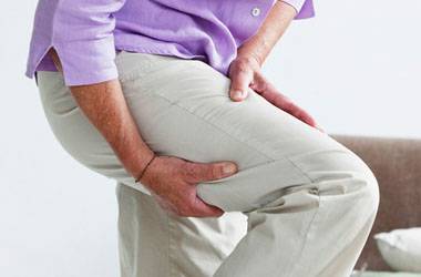 A seated person with hands near one knee