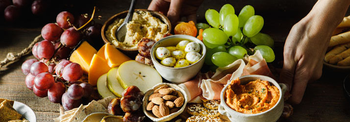 A board with fruit, cheese and other small dishes