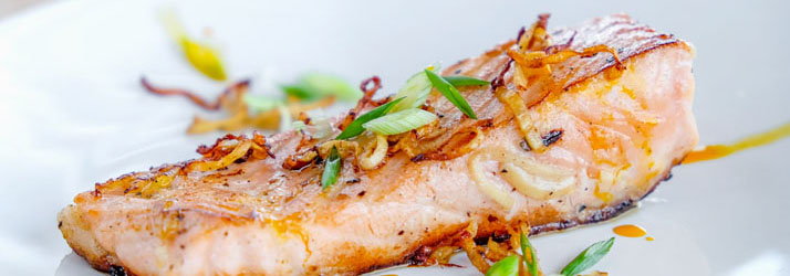 A cooked salmon fillet with herbs