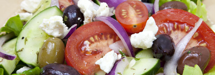 A salad with tomatoes, cucumber, olives and cheese