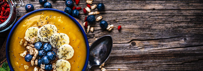A smoothie bowl topped with fruit and seeds